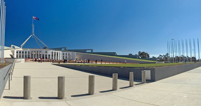 Parliament House in Canberra, visitors in distance, clear blue sky