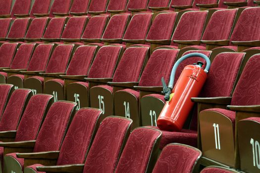 red fire extinguisher on red cinema seats, 