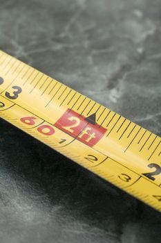 yellow measuring tape detail photo, centimeters and feet markings