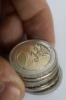 old man hands holding several two euro coins