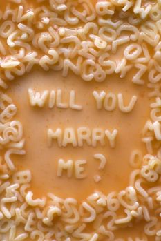will you marry me text made of pasta letters, ketchup tomato soup