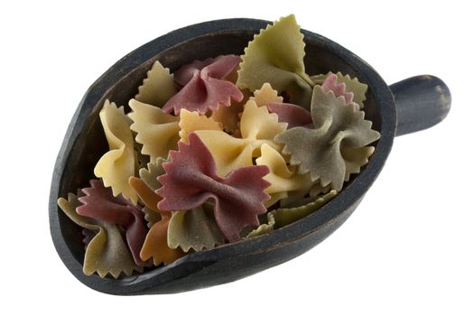 organic vegetable bowties pasta with spinach and red beets on a rustic wooden scoop isoalted on white