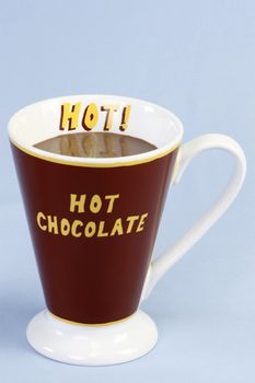 A mug of hot chocolate over light blue background