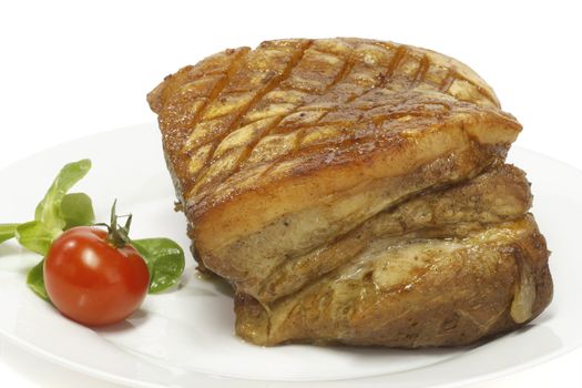 Crunchy pork roast on a plate over white background