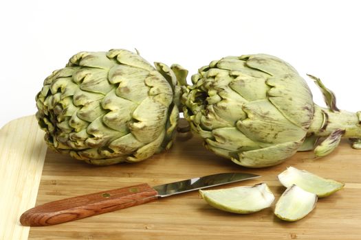 Preparation of fresh artichokes on a wooden plate
