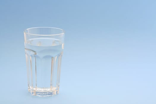 A glass of water with blue background