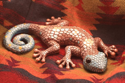 Colorful gecko on southwest aztec blanket.