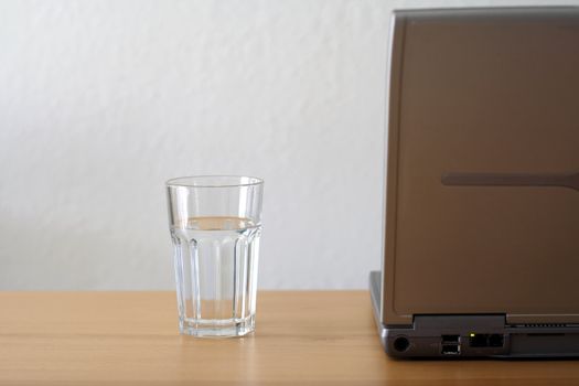 A laptop and a glass of water