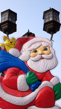 A cartoon Santa Clause with lamps and skies as backgrounds