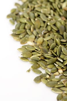 Pile of pumpkin seeds over white background