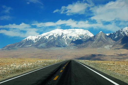 Landscape of a highway extending to the snow mountains