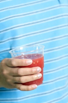 A woman holding a cup of watermelon juice