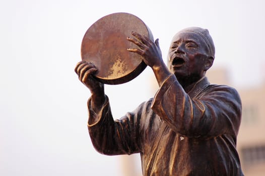 Statue of a man singing with drum