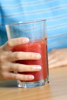 A woman holding a cup of watermelon juice