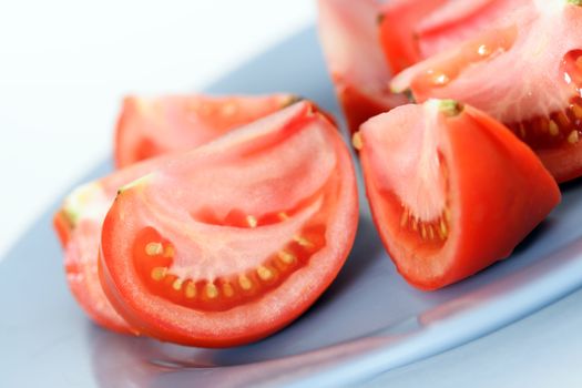  Slices of a tomato on a blue plate