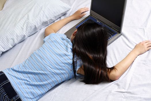 A girl resting on the bed after working with her laptop