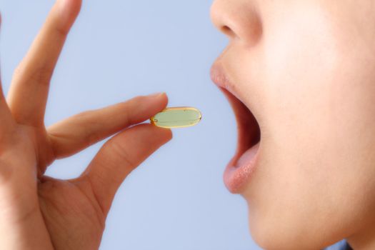 A woman taking a pill/vitamin