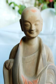 A sculpture of smiling buddha made of clay