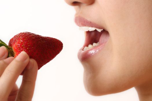 A woman eating a strawberry