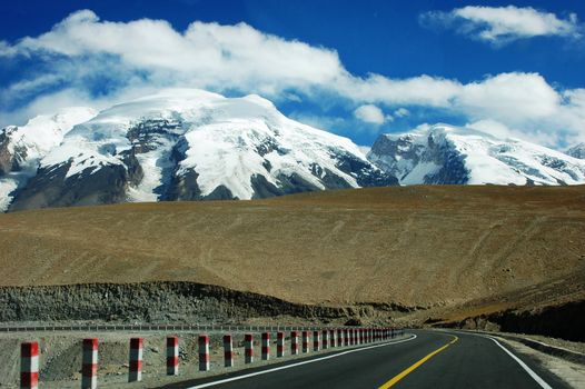 Landscape of a highway extending to the snow mountains