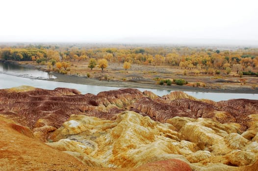 Landscape of colorful hills by the river in autumn