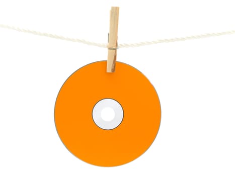 orrange Cd drying on the rope with clothes spins against the white background