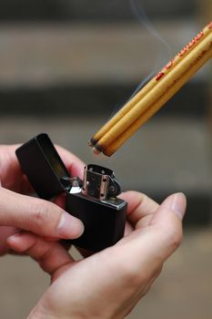 Lighting joss sticks for prayers with a lighter