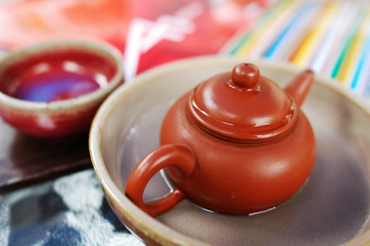 Closeup view of a pottery teapot with teacup 