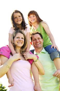 Portrait of happy family giving children shoulder rides