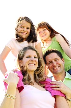 Portrait of happy family giving children shoulder rides