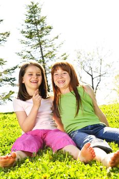 Portrait of happy girls sitting on grass