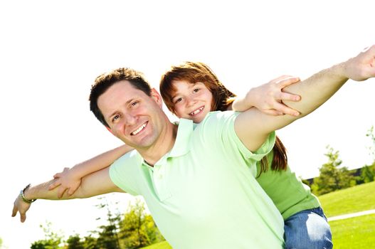 Portrait of happy father giving piggyback ride to child