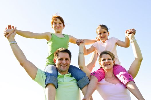 Portrait of happy parents giving children shoulder rides