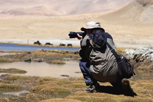 Photographer shooting pictures in the wilderness of highlands