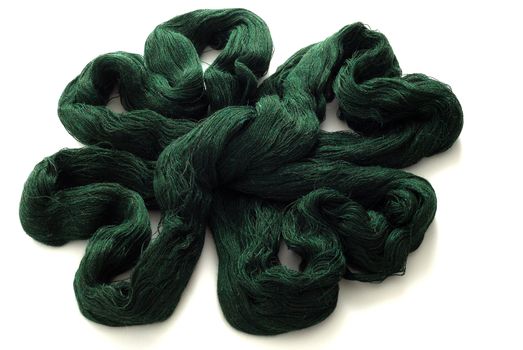 Green knitting yarn in shape of clover leaf on white background