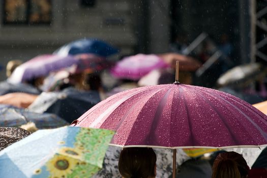 Busy street with crowd of people with umbrellas