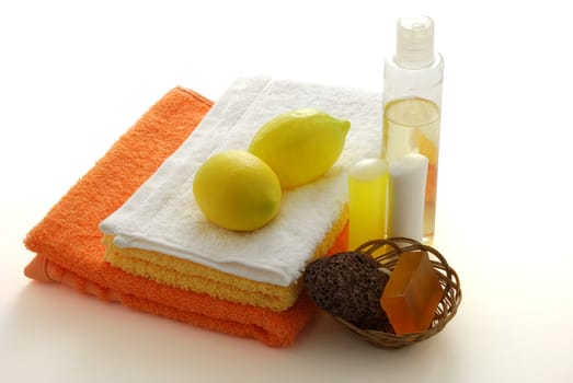 Lemon flavored SPA set including colored towels, soap, shampoo, moisturizer and pumice  on white background