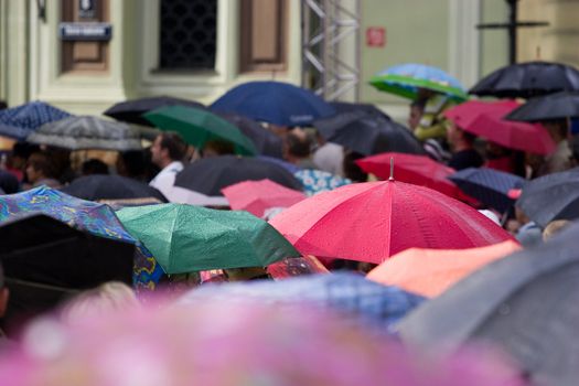 Busy street with crowd of people with umbrellas