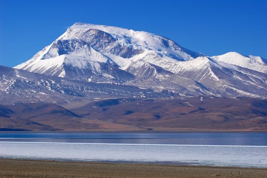 Landscape of snow mountains and blue lake in Tibet