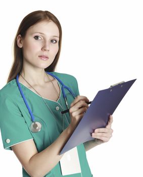Female doctor wearing green uniform and holding a clipboard with medical paperwork.