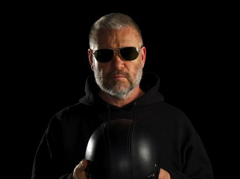 Biker on black background holding his half hat helmet