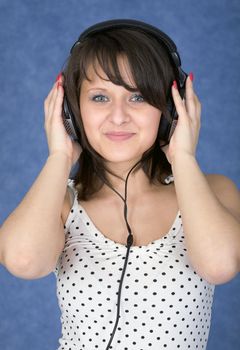 The girl in ear-phones on a blue background