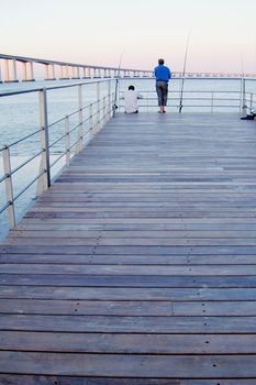 Fisherman at pier near Vasco da Gama Brige at Lisbon