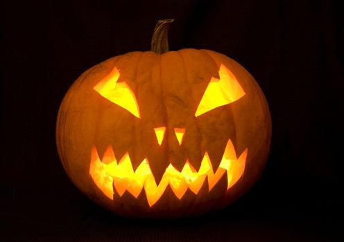 halloween decoration, a carved pumpkin illuminated with many candles