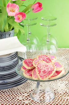 Valentine's Day cookies with dishes and flowers.