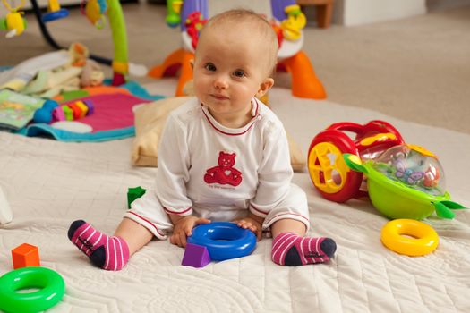 Caucasian baby girl playing on a floor.