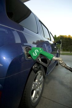 Car at gas pump with the American dollar sign on the handle