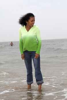 Beautiful black woman trying out the temperature of the water