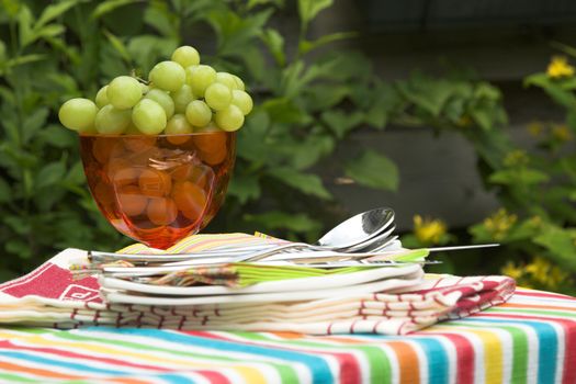 Table for two setout with a nice bowl of green grapes and plates ready