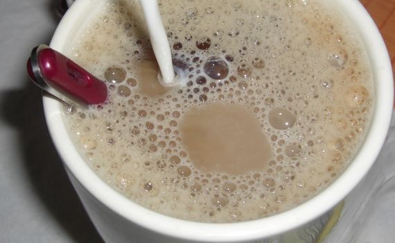 cup of coffee frothed up with fresh milk
